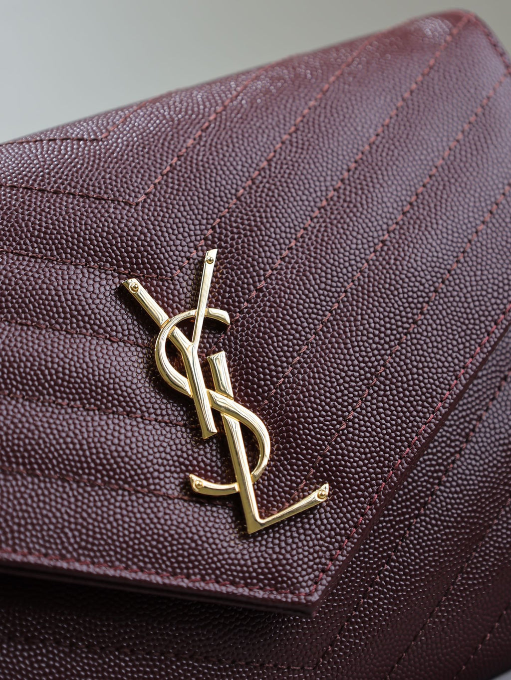 CASSANDRE CLUTCH 21 IN BORDEAUX RED LAMBSKIN GOLD HARDWARE